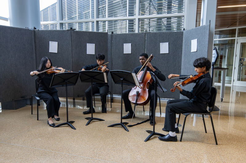 Four Panther Creek High School orchestra students playing their instruments
