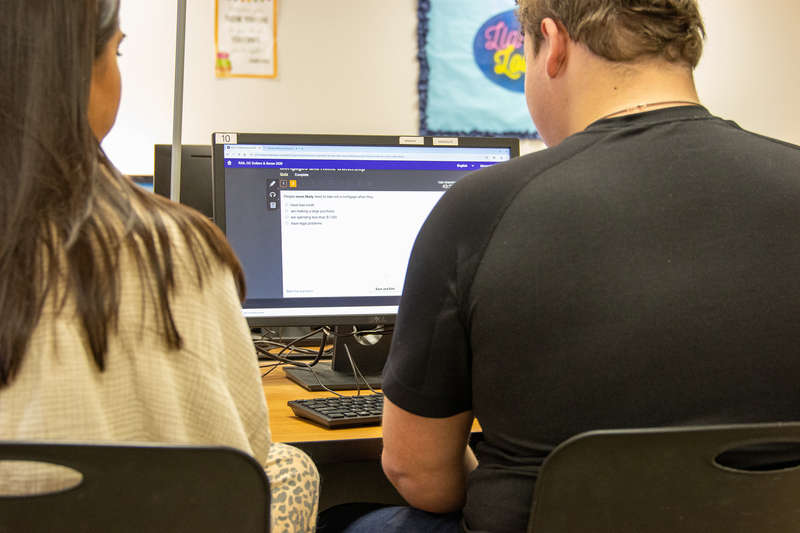A computer screen shows results of a quiz that a teacher and student are looking at