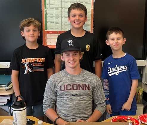 Joey Muldowney posing with students