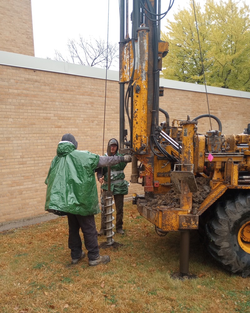 Workers boring soil