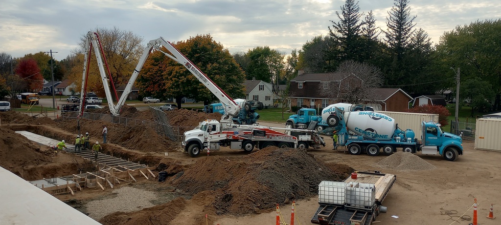 Placing concrete for Gym/Storm Shelter footings.