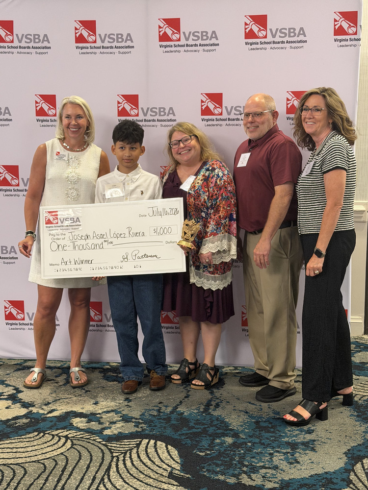 Group of 5 people with a young male student holding a large check in the amount of $1,000.