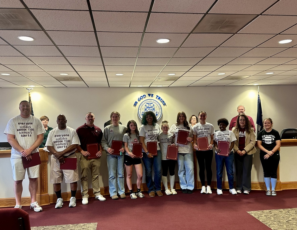 A group of people standing in a room, holding certificates, and smiling for a photo.