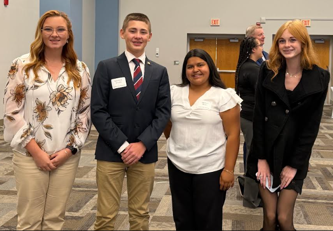 Four young adults pose for a photo with two women on either side of a man and another woman.