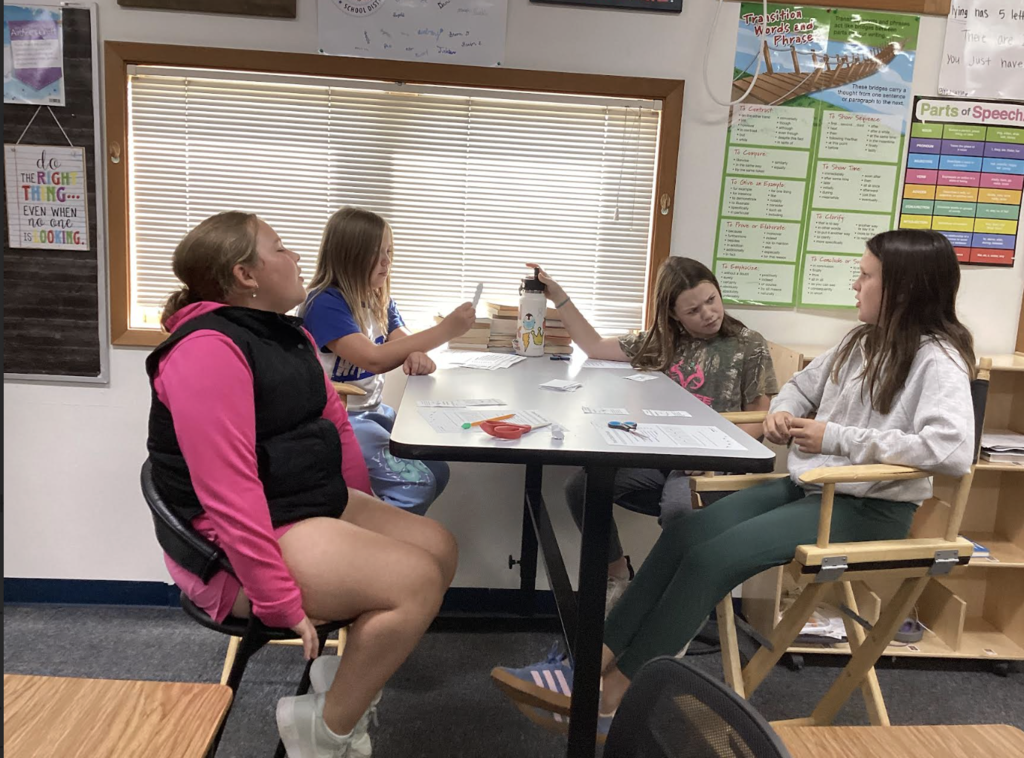 Students playing cards to learn about food chains