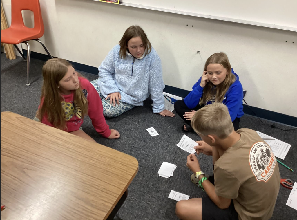 Students playing cards to learn about food chains
