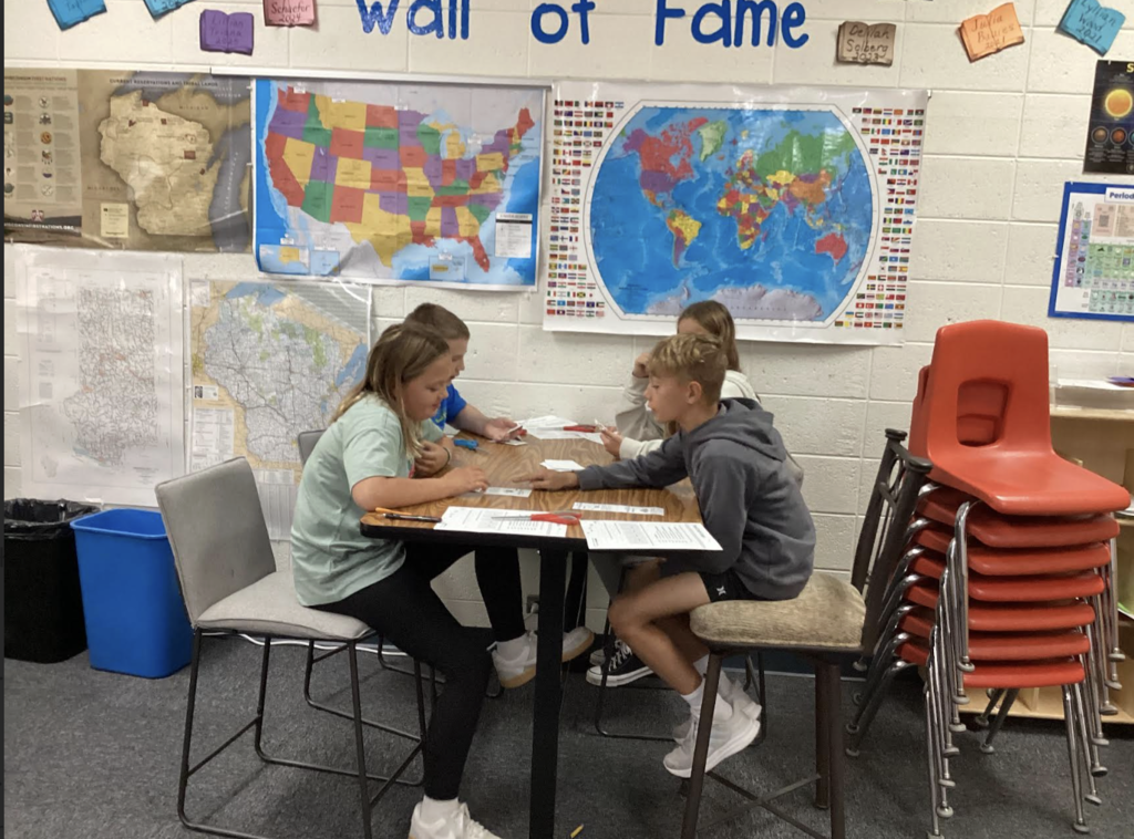 Students playing cards to learn about food chains