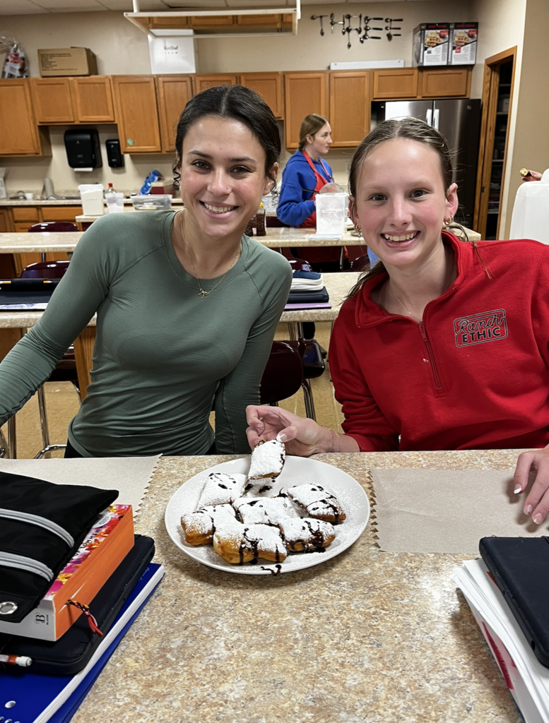 Students enjoying their finished Beignets. A French-style, deep-fried pastry made from yeast dough.