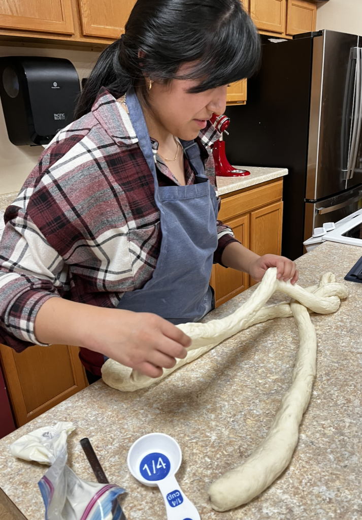 A student braiding their king cake dough. 