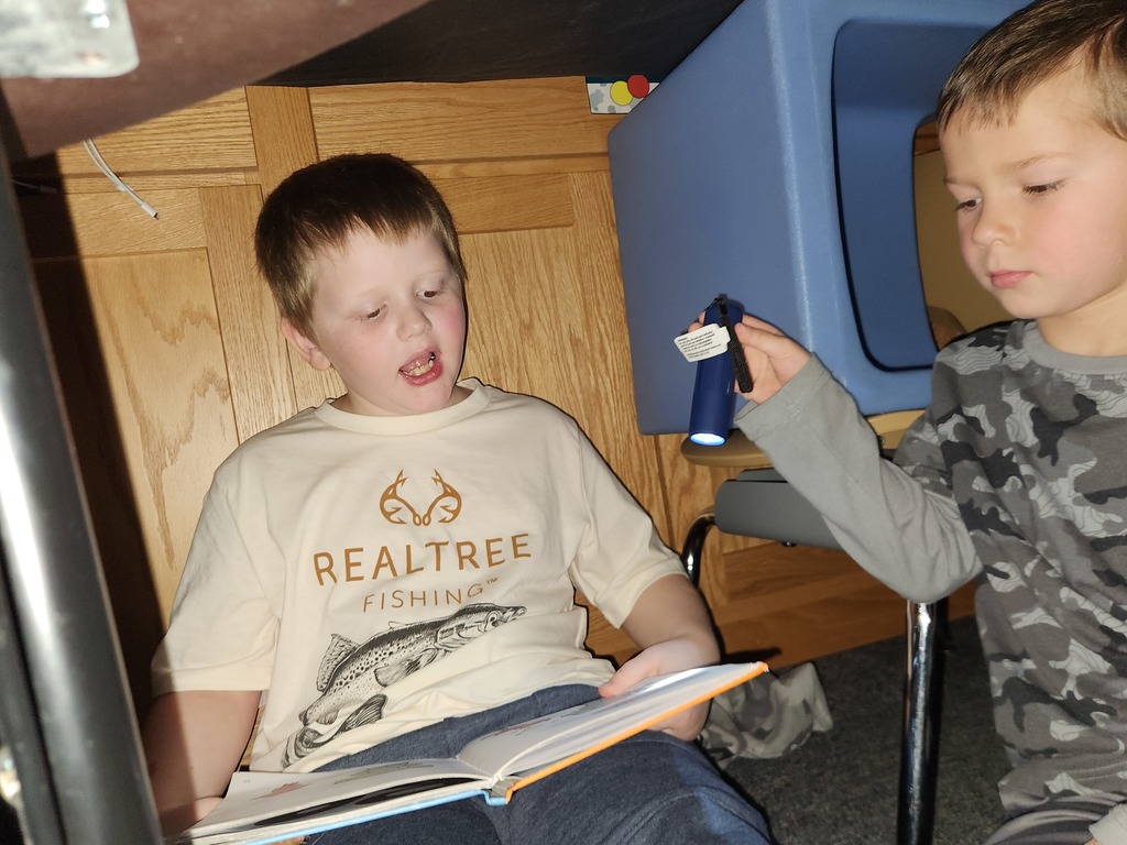 Students flashlight reading under forts