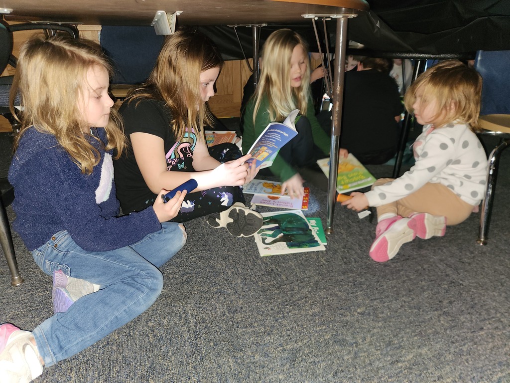 Students flashlight reading under forts