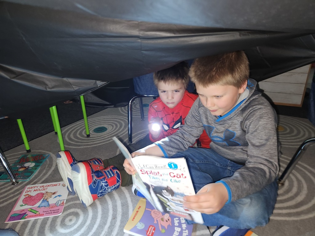 Students flashlight reading under forts