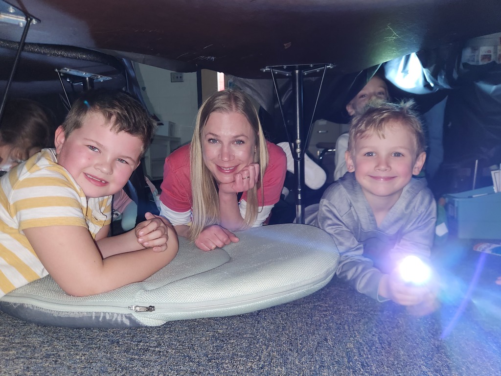 Students flashlight reading under forts
