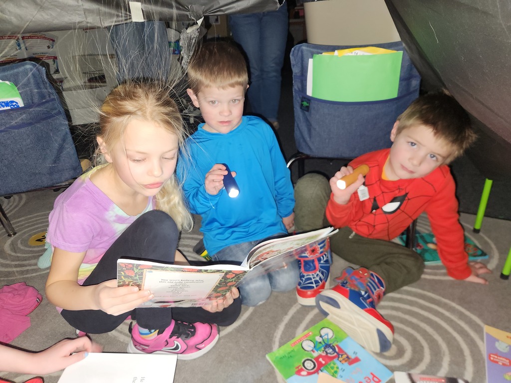 Students flashlight reading under forts