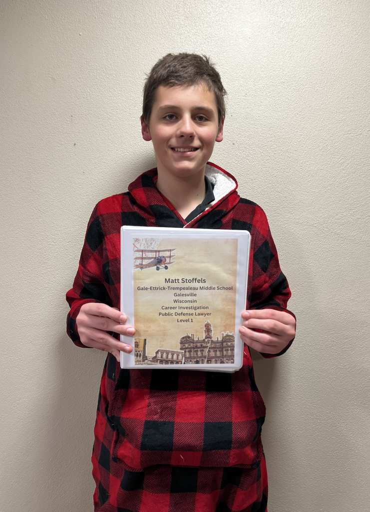 A student showing off their Career Investigation project. 