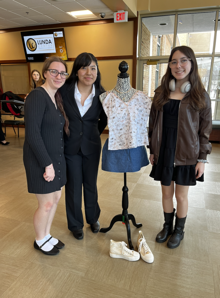 Students standing next to their Fashion Design mannequin. 