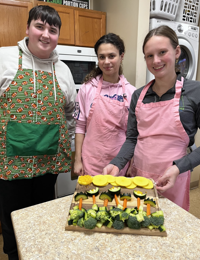 Students displaying their cut vegetable garden design.