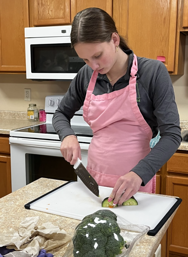 A student cutting cucumbers.