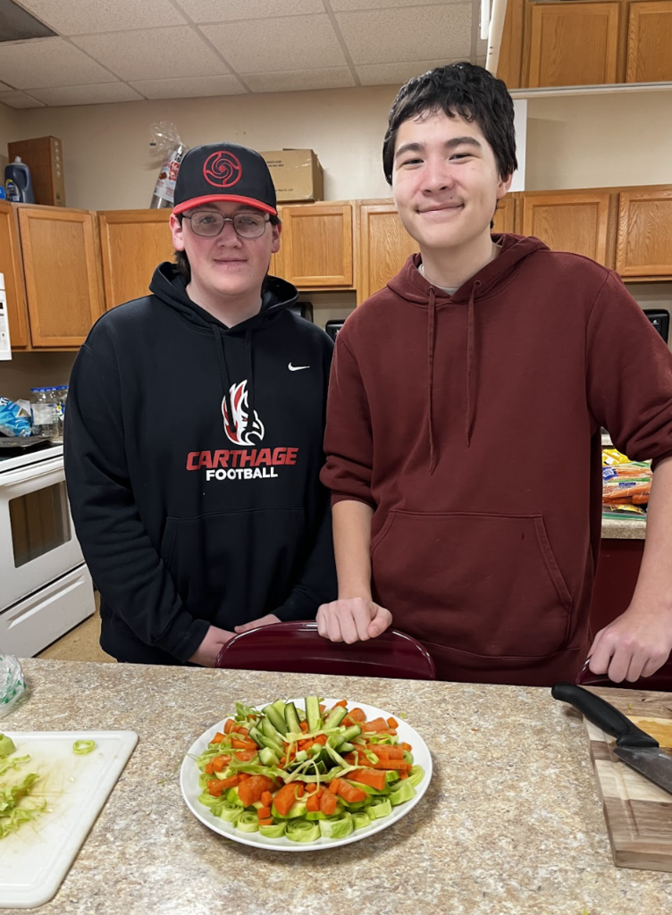 Students displaying their cut vegetable design.
