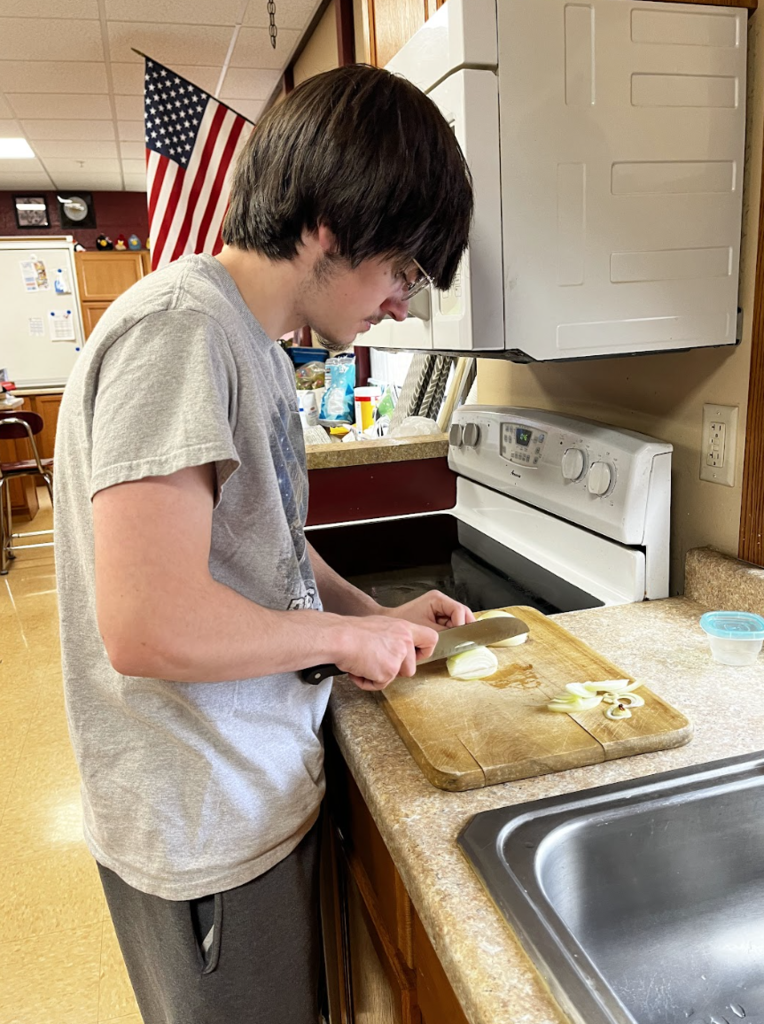 A student cutting onions.