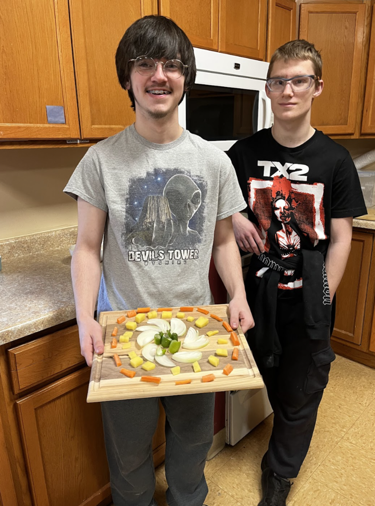 Students displaying their cut vegetable design.