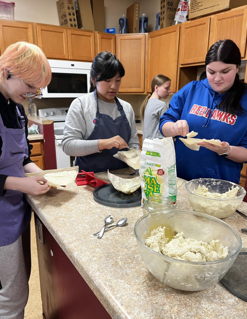 Students practicing the art of spreading masa.