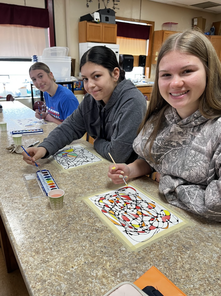 Students using watercolor on their neurographic art drawings.