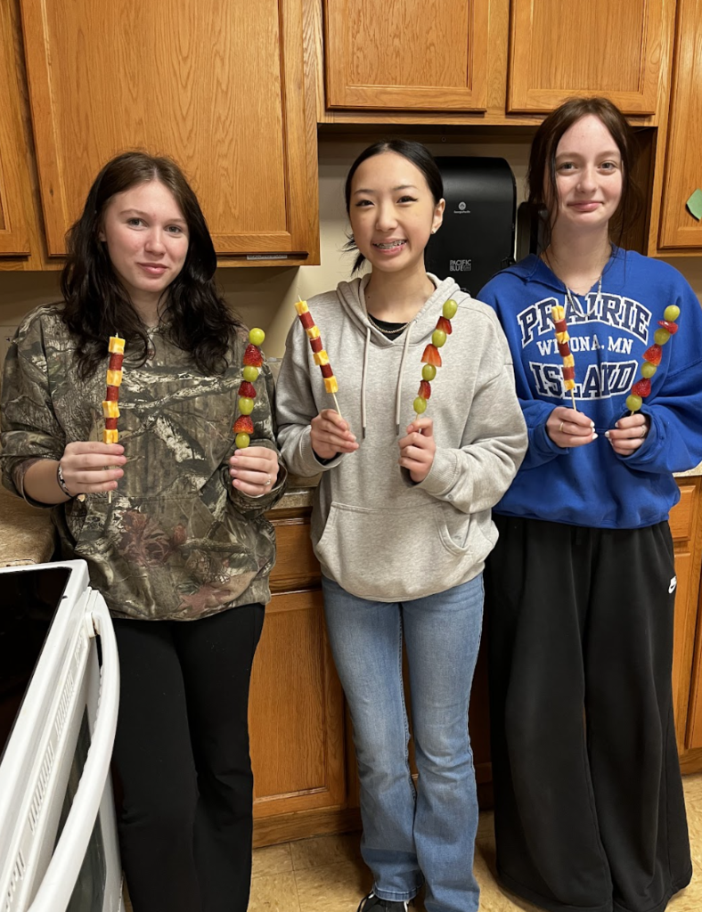 Students showing off their delicious fruit and charcuterie kabobs!
