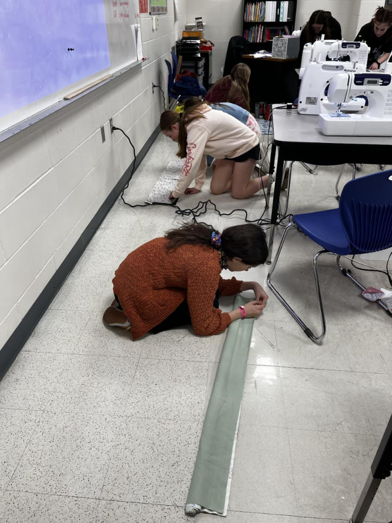 Students work on pinning their pillowcase fabric together. 