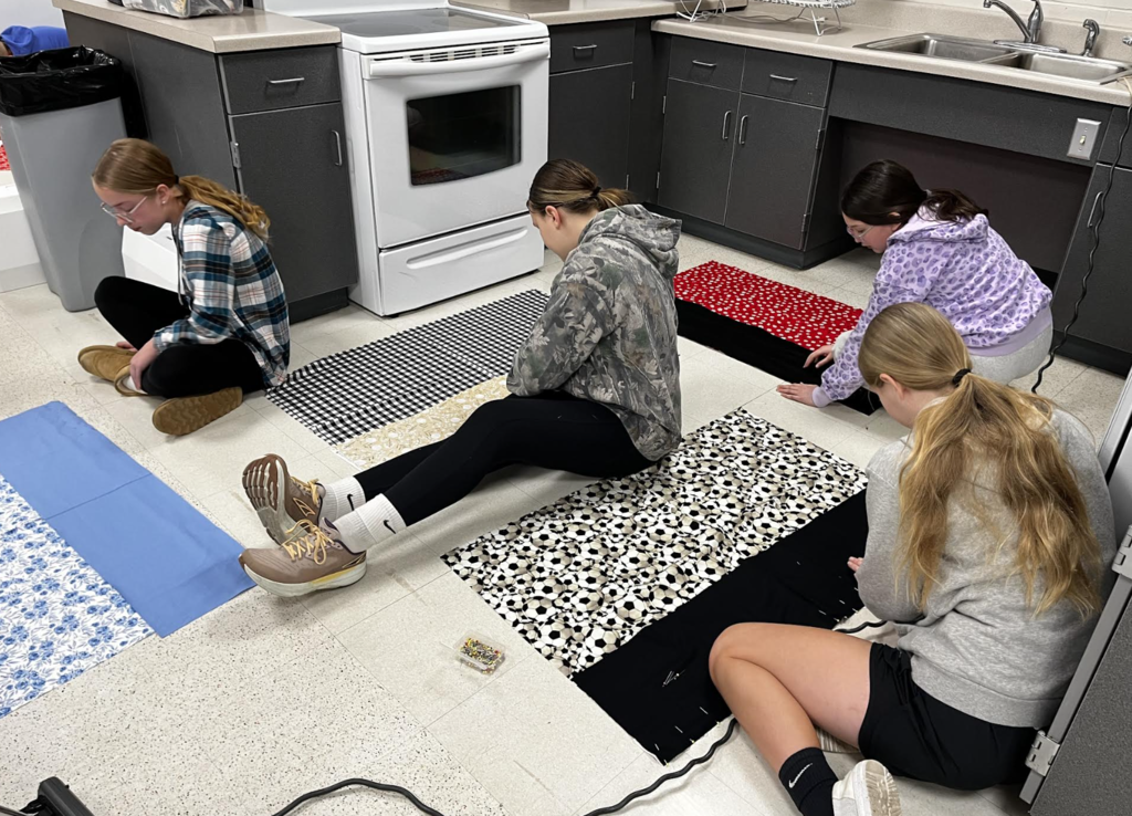Students work on pinning their pillowcase fabric together. 