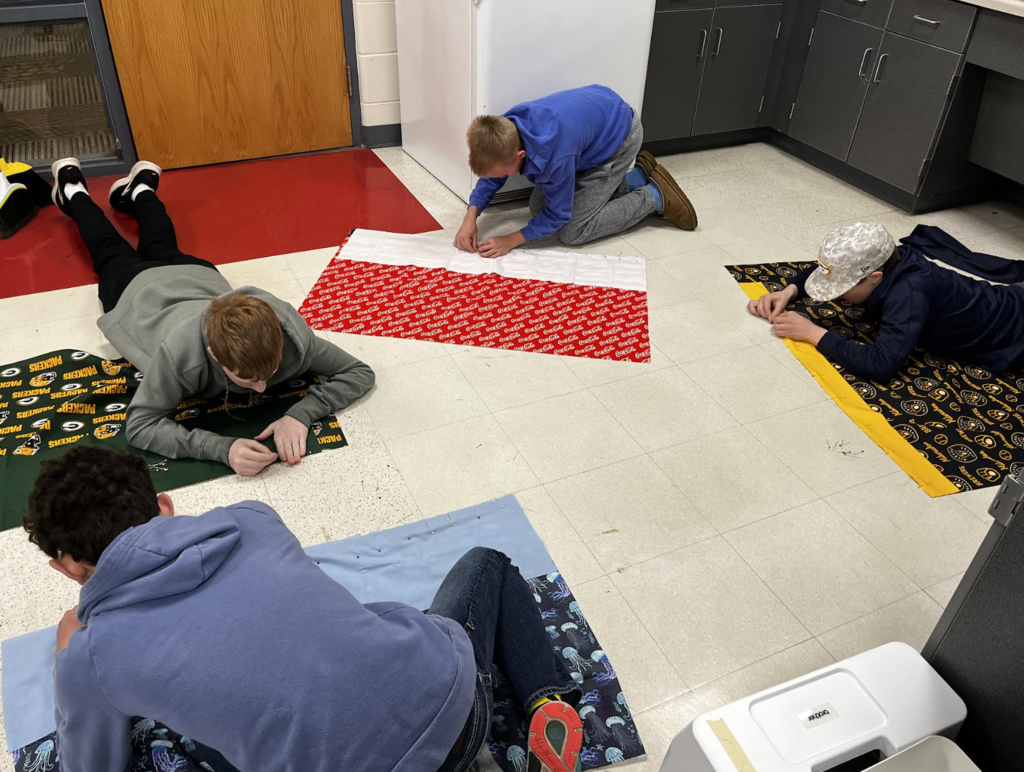 Students work on pinning their pillowcase fabric together. 