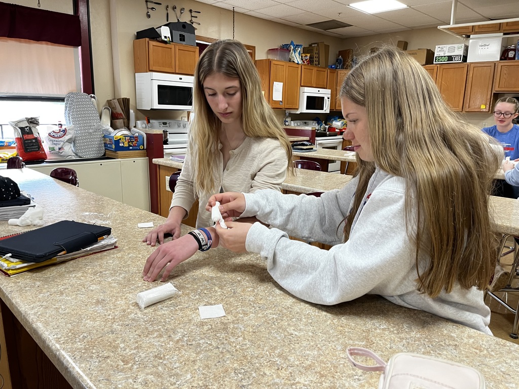 Two students practice caring for cuts and wounds.