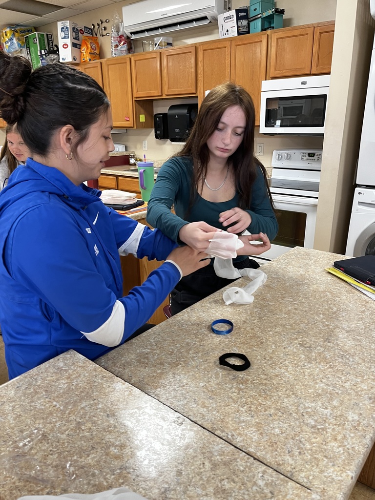Two students practice caring for cuts and wounds.