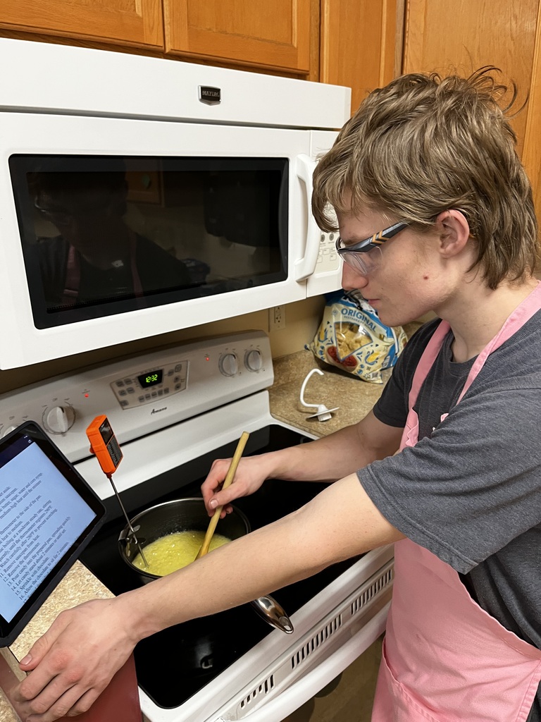 A student checking the temperature of their caramel. 