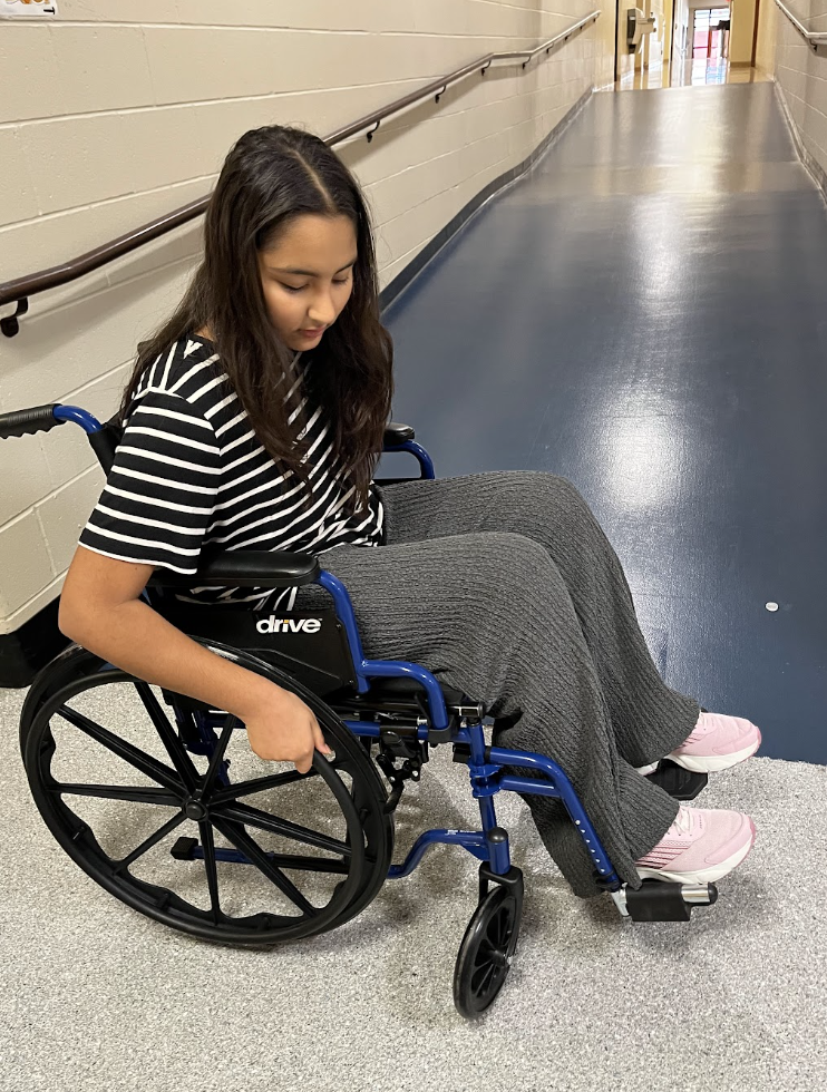 A student navigates the hallways in a wheelchair. 