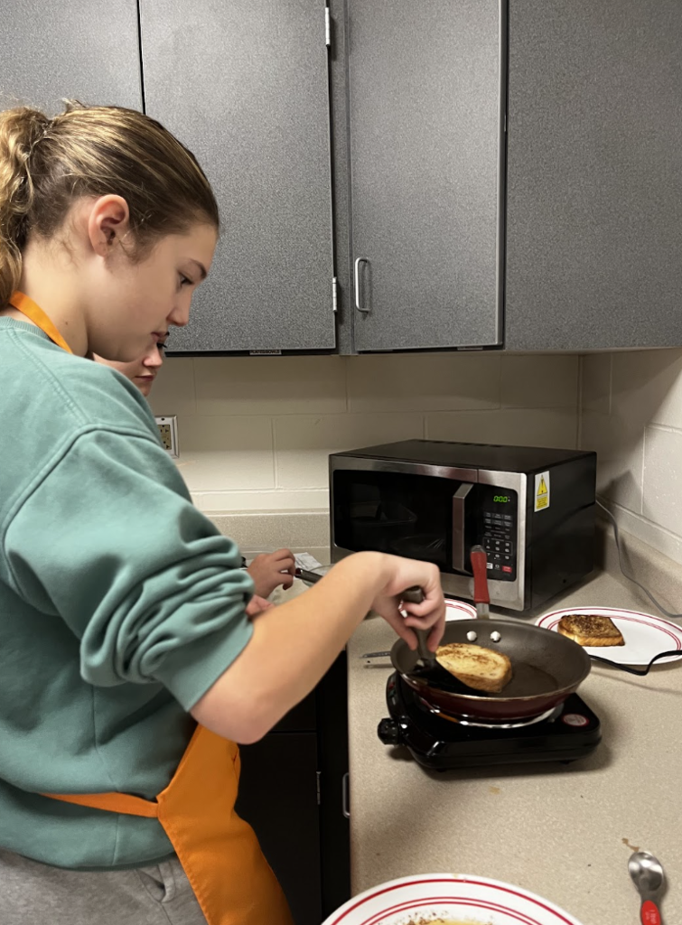A student checks if their French Toast is ready to flip. 