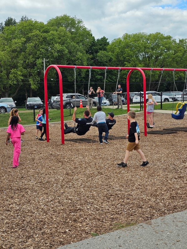 police officers having fun on the swings