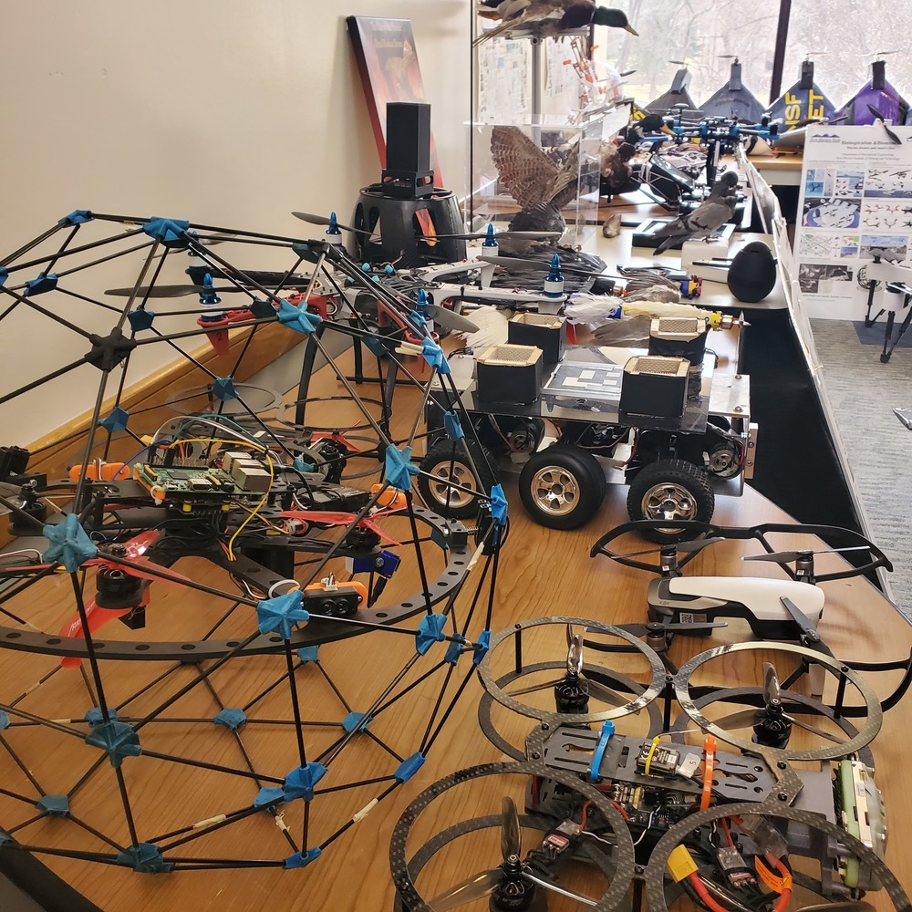 robot, brown table, white wall, big clear window in back