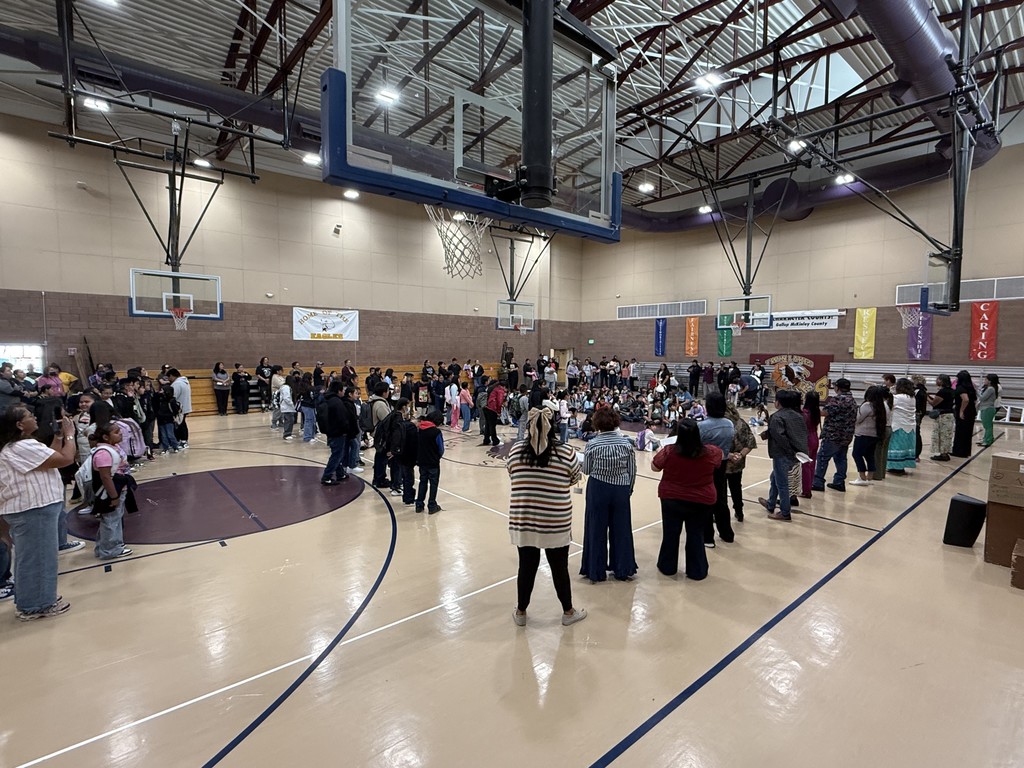 Image with staff facing students during first day of school assembly.