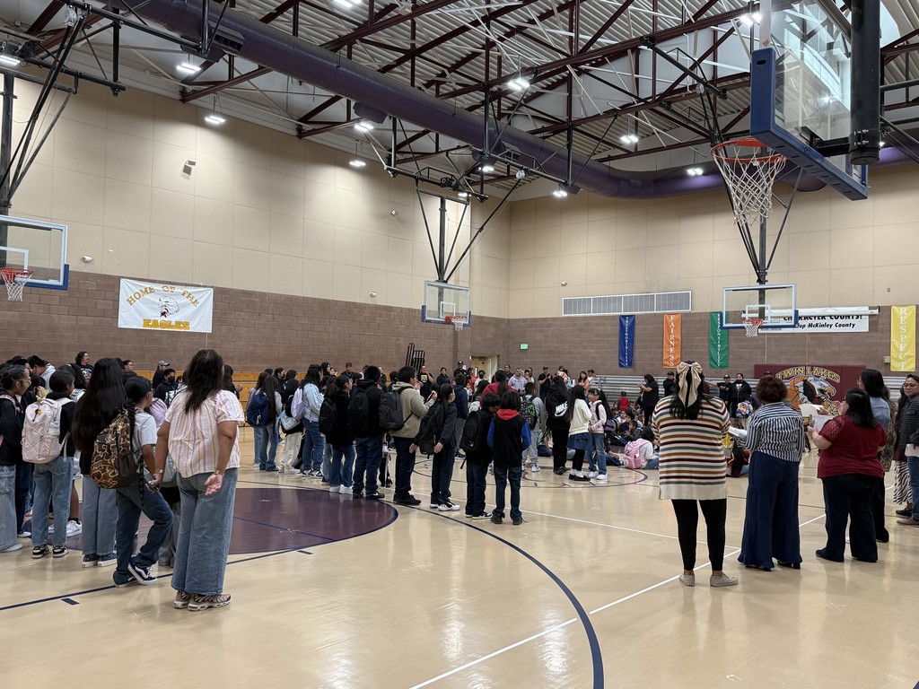Picture of students and staff facing away from camera during introductions.