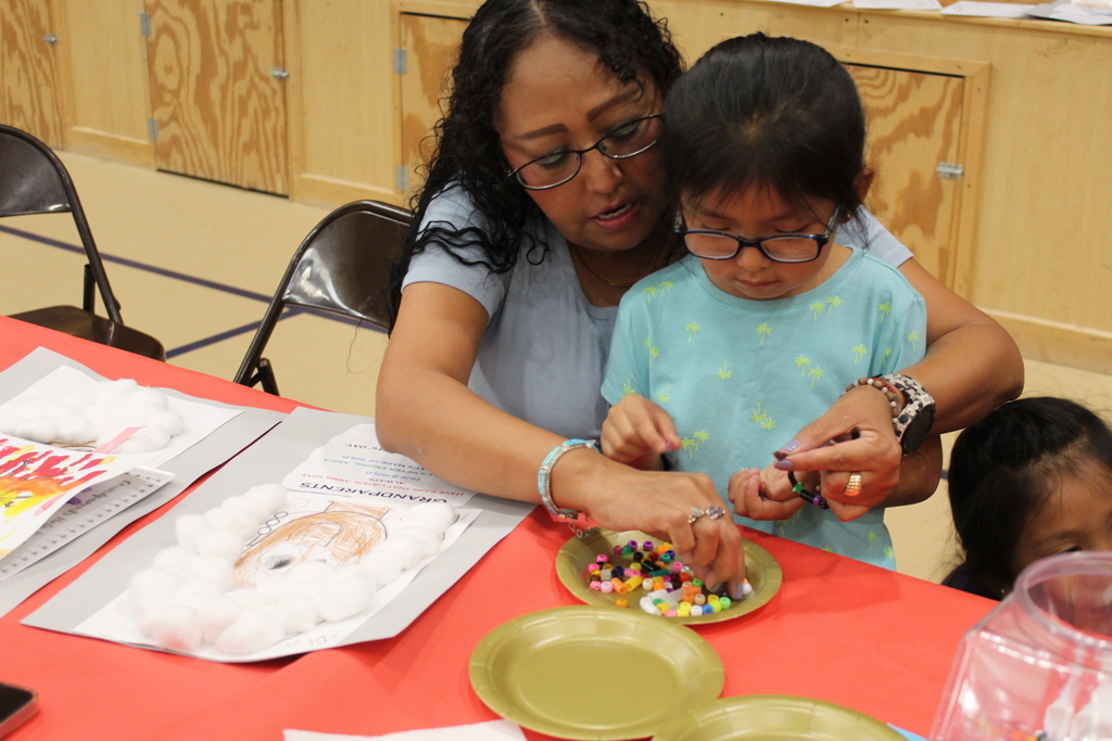 A grandmother working with her granddaughter on an activity.