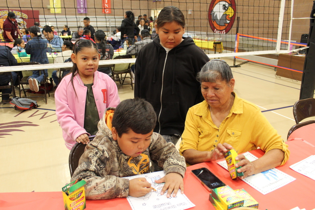 A grandmother and her grandchildren coloring together. 