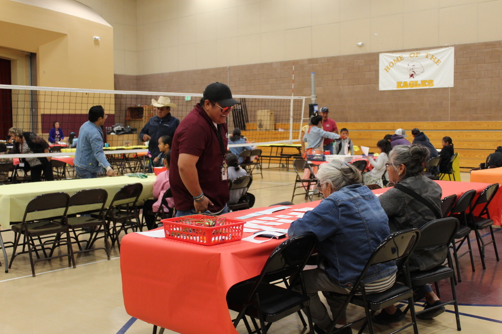 Mr. Claw talking with two grandparents in the Twin Lakes Gym.