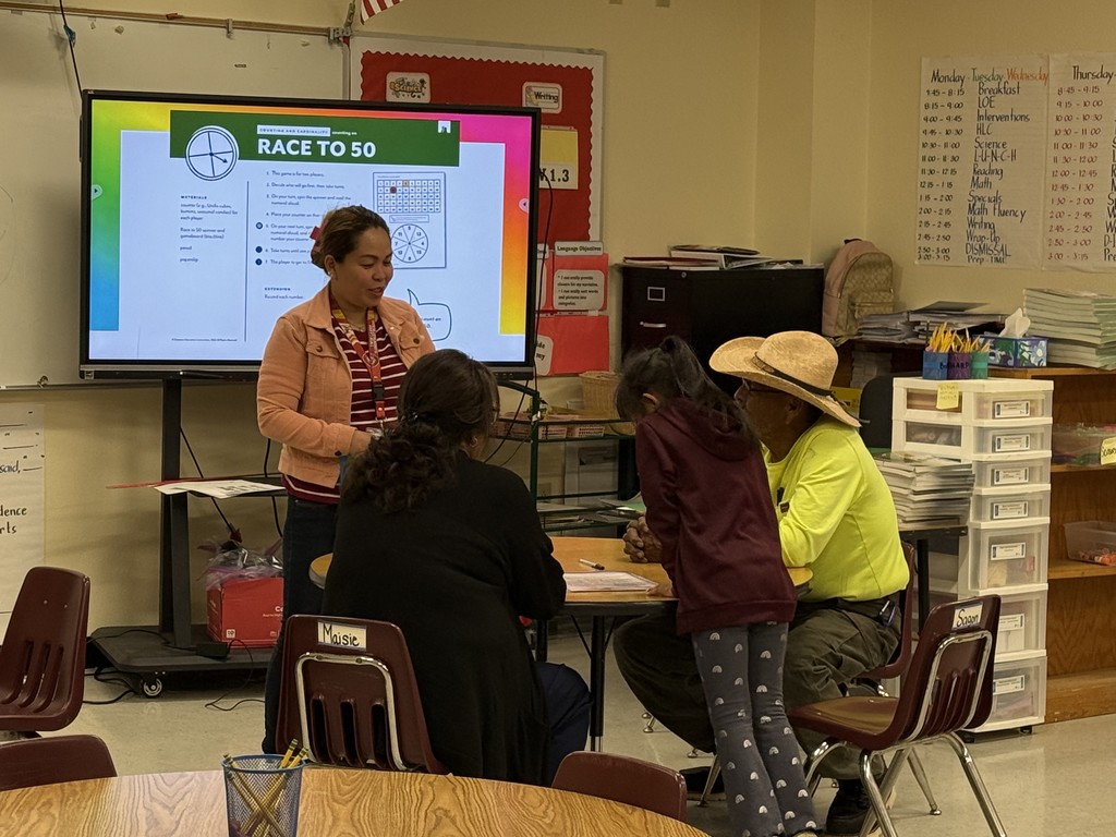 Ms. Abarquez one of our first grade teachers talking with a family and their student about the race to 50 math game.