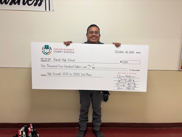 Mr. Martin holding the large check from the school district.