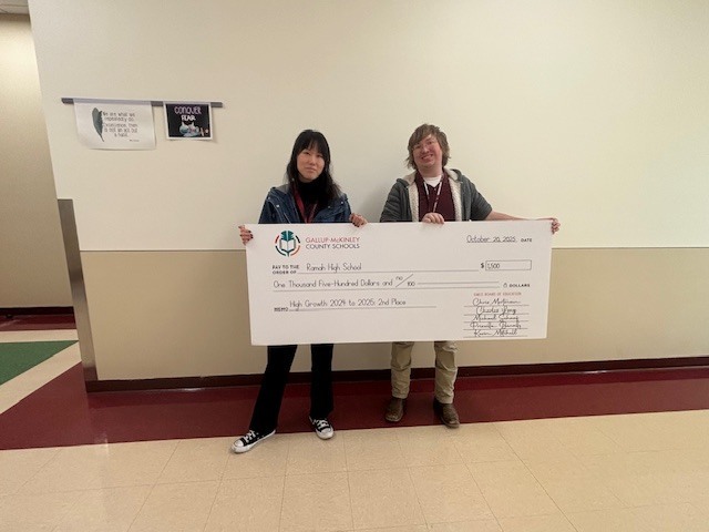 Ms. Shaw and Mr. Hamm holding the large check from the district.