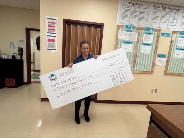 Mrs. Grassie holding the large check from the school district.