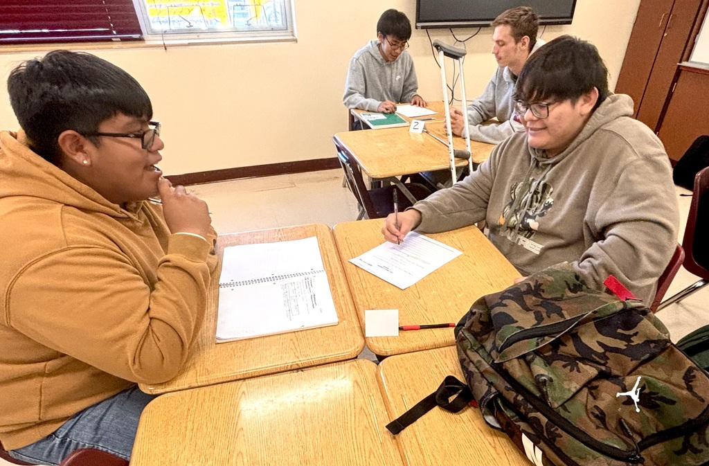 students discussing and working on bills