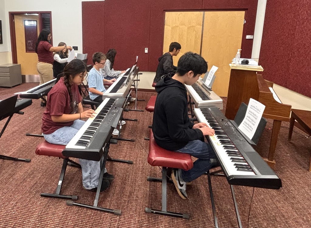 Students playing the electric pianos