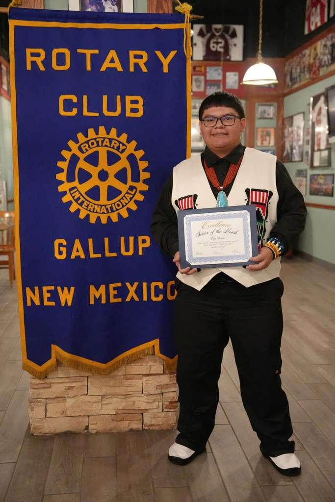 Elyn Garcia standing at the Rotary Club sign